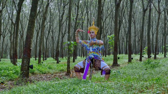 A tunnel of rubber trees stretches into the distance, forming a serene green corridor. Within this natural sanctuary, a Manora dancer rehearses her art, a cultural expression of Southern Thailand