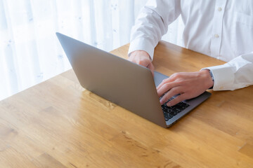 ノートパソコンを操作するビジネスマンの手元