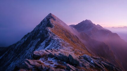Majestic mountain range at dawn with rugged peaks and colorful sky landscape.