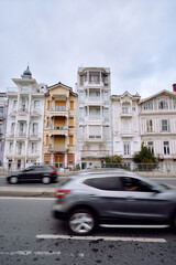 Vintage Urban Street Scene With Historical Architecture and Passing Cars