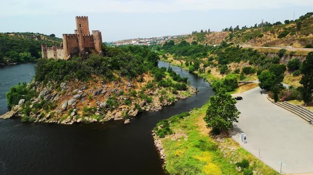 Ascending drone reveal shows Almourol Castle and boat on Tagus River near Tancos, Portugal