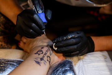 Tattoo artist carefully working on a client’s leg design under focused light. Concept of precision, artistry, creativity, and modern body art in a professional tattoo studio