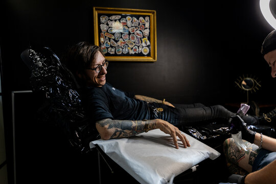 Tattoo artist and male client discussing design and placement before the session. A candid look into the consultation process in a professional tattoo studio