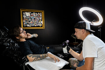 Tattoo artist and male client discussing design and placement before the session. A candid look...
