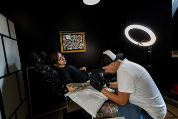 Tattoo artist and male client discussing design and placement before the session. A candid look...