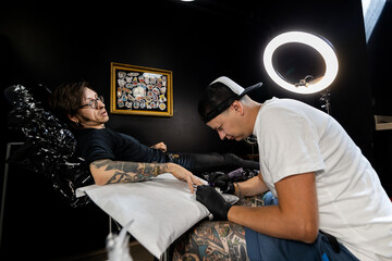 Tattoo artist and male client discussing design and placement before the session. A candid look...