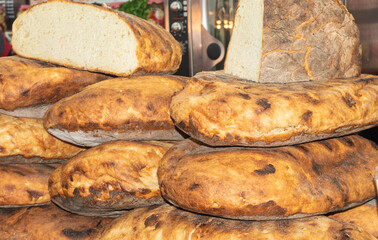 Closeup of homemade rustic bread.  Traditional sourdough bread cut in half on a rustic background. Fresh round homemade bread. Concept of traditional leavened bread baking methods. Healthy food
