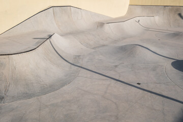 Concrete skatepark with smooth ramps and curves surrounded by Dubai’s modern skyscrapers