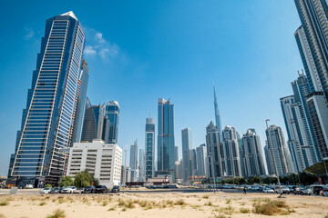 Dubai business bay building, Cluster of tall buildings against blue sky with clouds palm trees, skyscrapers, background for business, real estate background
