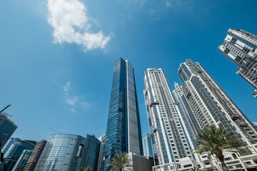 skyscrapers in downtown Dubai against blue sky with clouds, low angle view 