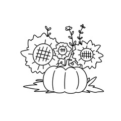 A pumpkin is sitting on the ground next to a bunch of flowers