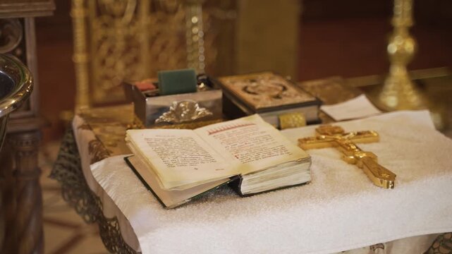 Religious attributes for the rite of baptism in the Orthodox Church. An ancient book with sacred text of prayers and golden cross