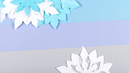 Colorful paper snowflakes, light blue and white, arranged artfully on a pastel background of various shades.