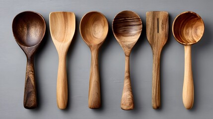 Arrangement of six wooden spoons on a gray surface.