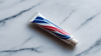 Fototapeta premium Toothpaste tube with red, white, and blue stripes on a marble surface