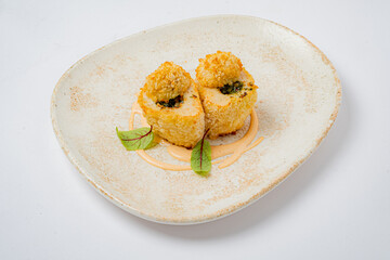 Crispy fried delicacy displayed beautifully on an elegant plate, garnished with vibrant greens