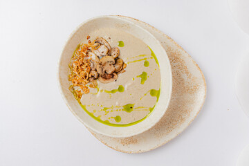 Creamy mushroom soup topped with crispy onions and green drizzle, perfect for any meal