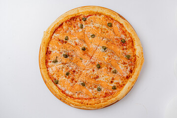 Enjoy a fresh pizza with smoked salmon, capers, and melted cheese in a cozy setting