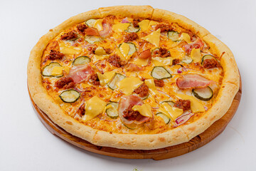 A mouthwatering pizza featuring layers of cheese, ham, and crunchy pickles ready to be enjoyed