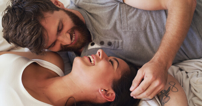 Love, relax and couple with laughing on bed for funny conversation, bonding together and support. Home, people and happy with affection in bedroom for relationship joke, marriage security and trust