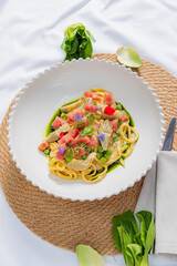 A vibrant pasta dish showcases fresh veggies and herbs, ideal for dining