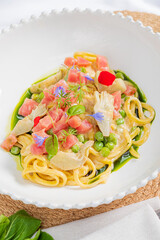 Savor the exquisite pasta adorned with tomatoes, herbs, and vibrant flowers, celebrating flavor