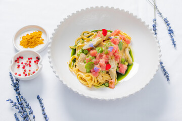 A vibrant pasta dish with artistic garnishes, displayed in elegant decor