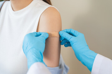 Fototapeta premium Vaccination coronavirus, hand of doctor apply plaster, bandage after doctor giving vaccine, injection dose on arm patient, immunization disease prevention against flu pandemic influenza, health care.