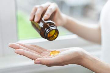 Dietary supplement concept, happy asian young woman hand holding fish oil pills, drugs medical...