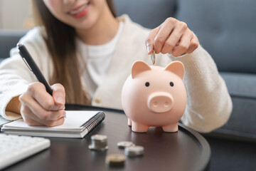 Financial, asian young woman, girl putting stack coins on table for calculate cost sitting in...