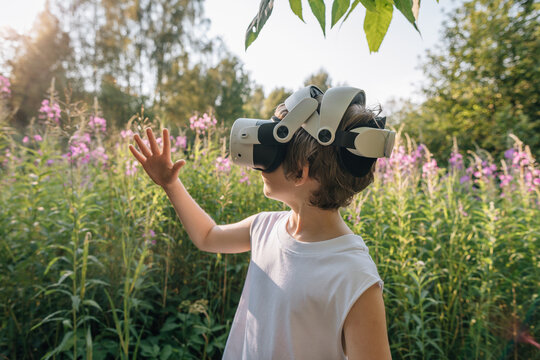 Man child in virtual reality glasses looking at hand