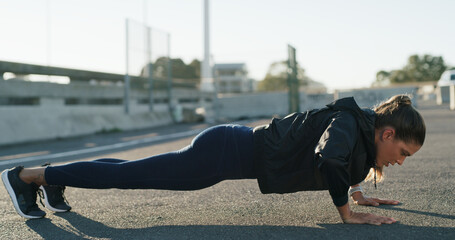 Woman, push up and exercise in street for fitness, challenge and routine for wellness on bridge. Person, outdoor and workout in city with muscle development, health or training on ground in Spain