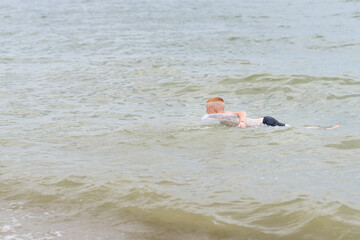 A teenager swings on the waves on an inflatable swimming ring. peaceful tropical summer holiday,...