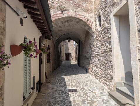 Caratteristico vicolo in pietra di un antico borgo medievale,In primo piano si nota un arco in pietra