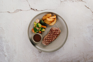 Grilled Steak Dinner with Potato Wedges and Sauteed Vegetables