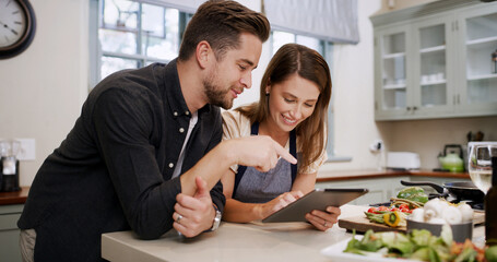 Cooking, recipe and couple with tablet in kitchen for dinner, supper and meal prep in home. Conversation, food and man with woman on digital tech for online tutorial, ingredients or culinary cuisine