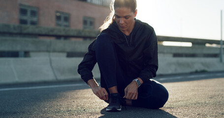 Woman, runner and tie shoelaces in city, bridge and reflection with fitness routine in morning....