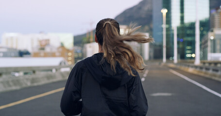 Back, running and woman in city for exercise, cardio health and wellness outdoor. Road, marathon...