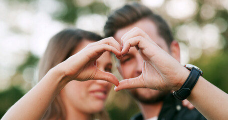 Happy, heart and hands of couple in park for love, bonding and relationship together on weekend....