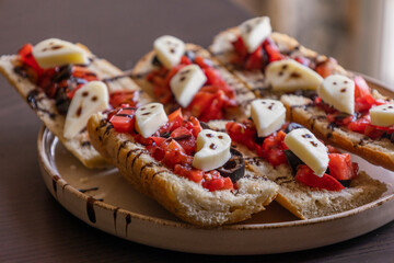 halloween party appetizer bruschettas with fresh tomato and small ghosts made from mozzarella, fun and festive snack