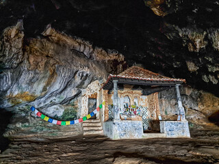 Dark interior of Lapa de Santa Margarida in Arrabida, Setubal, Portugal. Cave with small chapel of spontaneous worship
