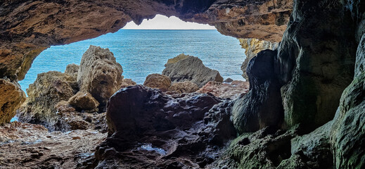 Dark interior of Lapa de Santa Margarida in Arrabida, Setubal, Portugal. Cave with small chapel of spontaneous worship