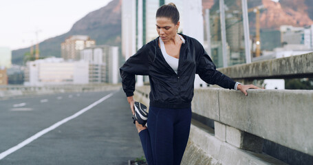 Runner, woman and stretching legs on road for wellness, health or exercise preparation outdoor....