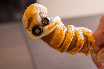 fun halloween sausage mummy snack wrapped in puff pastry close up