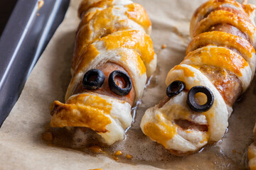 fun halloween sausage mummy snack wrapped in puff pastry close up