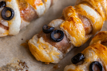 fun halloween sausage mummy snack wrapped in puff pastry close up