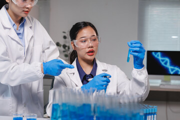 Scientists analyzing blue liquid in test tube in laboratory
