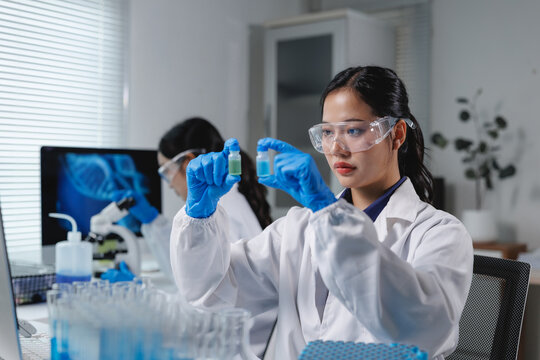 Scientist comparing two vials in laboratory research setting