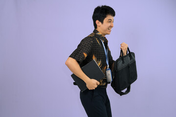 young professional wearing batik shirt with backpack and journal books , office man concept
