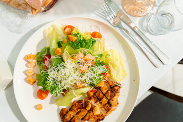 Caesar salad with chicken is a combination of crispy lettuce leaves, juicy chicken fillet, golden croutons and grated parmesan. Olive oil and lemon juice dressing adds freshness.